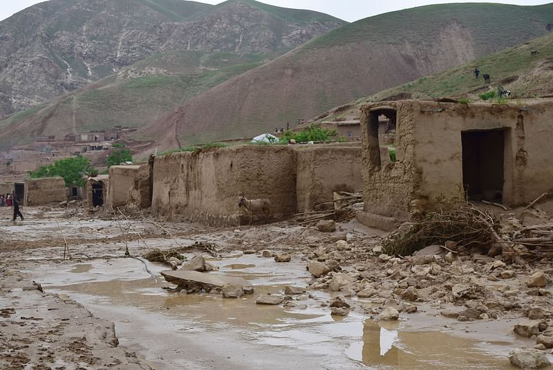 A donkey stands amid debris next to damaged houses along a mud covered road following a flash flood after a heavy rainfall in Sheikh Jalal village of Baghlan-i-Markazi district in Baghlan province on May 11, 2024