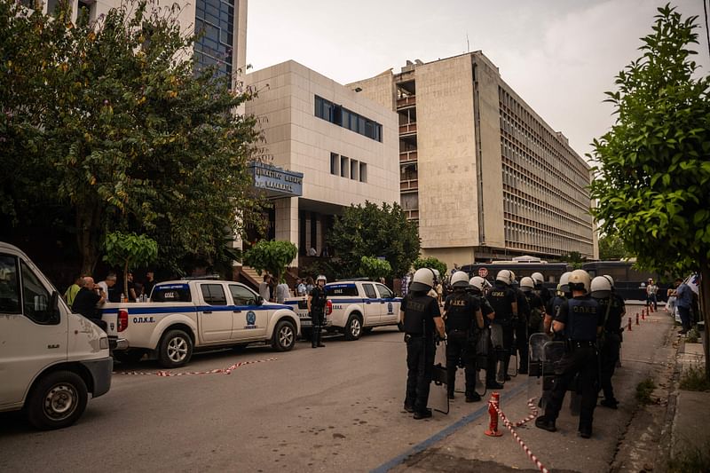 Police officers stand guard outside Kalamata courthouse, southwestern Greece, on the sideline of the trial of nine accused smugglers, on 21 May 2024.