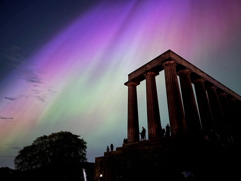 This handout photo taken and released by Jacob Anderson shows the northern lights or aurora borealis during a solar storm over the National Monument of Scotland in Edinburgh on 10 May 2024.