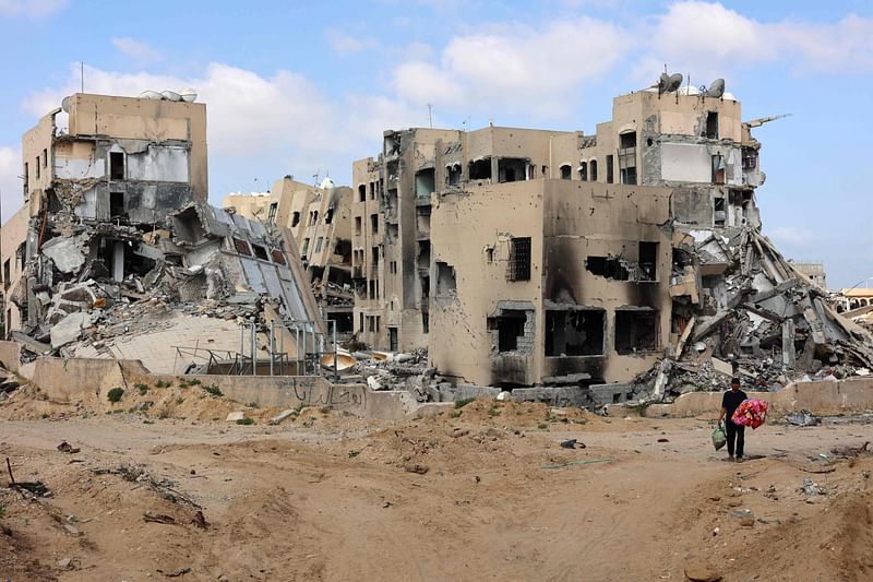 A Palestinian man carries belongings in Beit Lahya in the northern Gaza Strip on 4 May  2024, amid the ongoing conflict between Israel and the militant group Hamas.