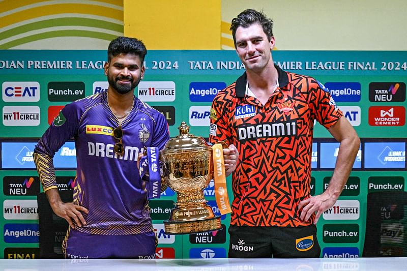 Kolkata Knight Riders' captain Shreyas Iyer and his Sunrisers Hyderabad's counterpart Pat Cummins (R) pose with the Indian Premier League's trophy for photos during a press conference at the MA Chidambaram Stadium in Chennai on 25 May 2024, on the eve of their Indian Premier League (IPL) Twenty20 final cricket match.