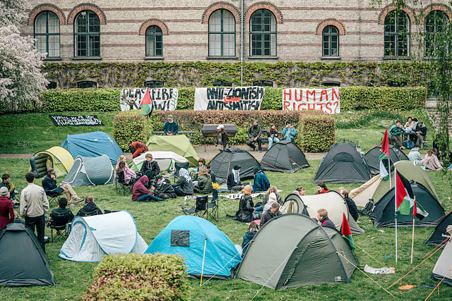 Students gather near banners at an encampment at the University of Copenhagen's City Campus, at the old Municipal Hospital amid the ongoing conflict between Israel and the Palestinian Islamist group Hamas, in Copenhagen, Denmark, 6 May, 2024.