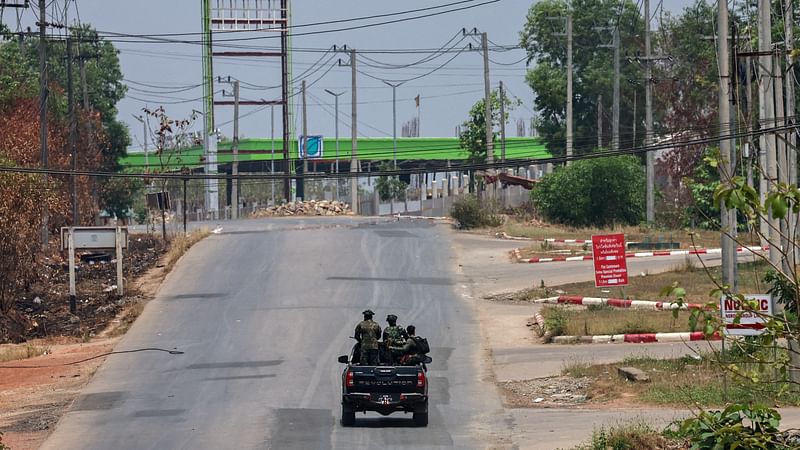 Soldiers from the Karen National Liberation Army patrol on a vehicle, next to an area destroyed by Myanmar's airstrike in Myawaddy, the Thailand-Myanmar border town under the control of a coalition of rebel forces led by the Karen National Union, in Myanmar, on 15 April, 2024