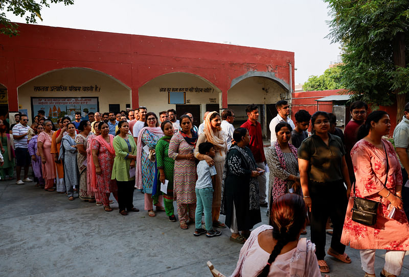 Voters line up to cast their votes outside a polling station during the sixth phase of the general election in Sonipat, in the northern Indian state of Haryana, India, 25 May 2024.