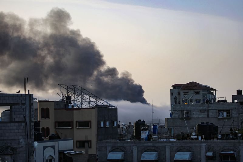 Smoke rises above building at sunrise, in the aftermath of Israeli bombardment in Rafah in the southern Gaza Strip on 10 May 2024, amid the ongoing conflict between Israel and the Palestinian Hamas movement.