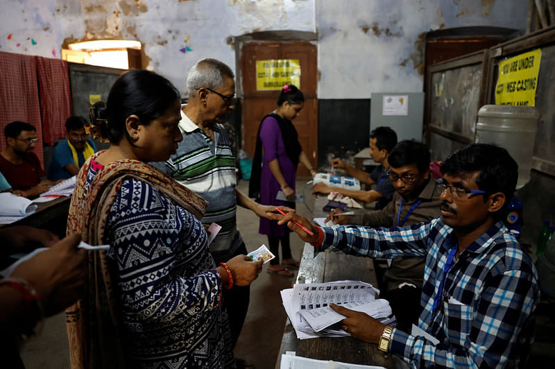 People get their names checked in voters' lists inside a polling station during the fifth phase of India's general election in Howrah district in the eastern state of West Bengal, India, 20 May, 2024.