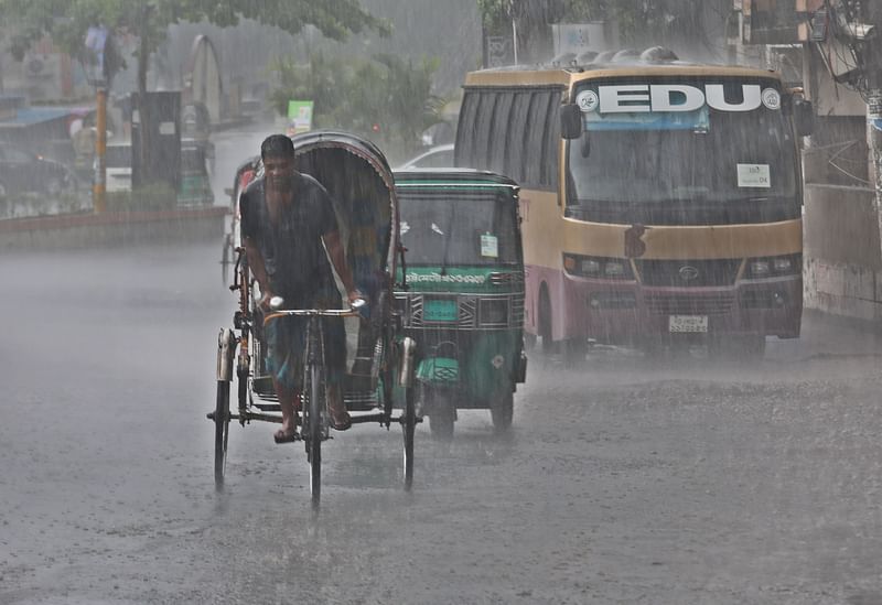 A man pulls a rickshaw amid heavy rainfall in Probartak intersection in Chattogram on 2 May 2024.