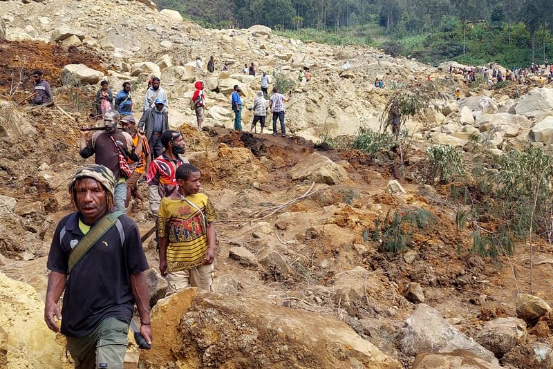 Locals gather at the site of a landslide at Mulitaka village in the region of Maip Mulitaka, in Papua New Guinea's Enga Province on 26 May 2024. More than 670 people are believed dead after a massive landslide in Papua New Guinea, a UN official told AFP on 26 May as aid workers and villagers braved perilous conditions in their desperate search for survivors.