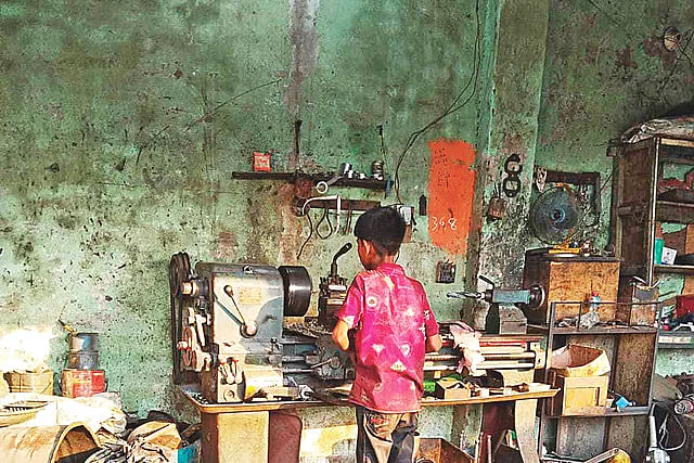 A 12-year-child is working hazardous work at a workshop in Keraniganj. He is cutting pipe with a heavy machine. The picture was taken on 24 April.