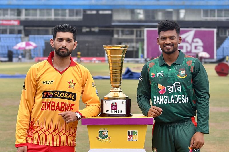 Bangladesh’s captain Najmul Hasan Santo (R) and Zimbabwe's captain Sikandar Raza pose for a picture with the series trophy at the Zahur Ahmed Chowdhury Stadium in chittagong on 2 May, 2024