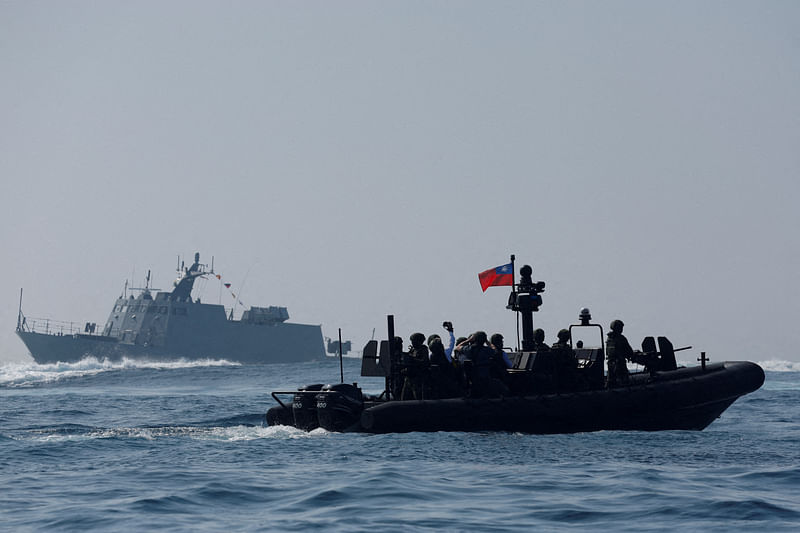 Members of Taiwan’s Navy and media onboard a special operation boat navigate near a Kuang Hua VI-class missile boat, during a drill part of a demonstration for the media, to show combat readiness ahead of the Lunar New Year holidays, on the waters near a military base in Kaohsiung, Taiwan on 31 January, 2024