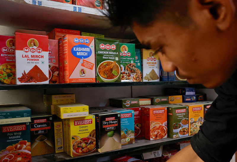 A man stands near the spice boxes of MDH and Everest kept on the shelf of a shop at a market in New Delhi, India, on 29 April, 2024