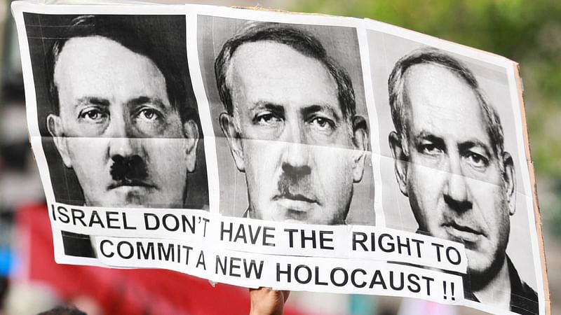 A protestor holds a sign, bearing portrait of Israeli Prime Minister Benjamin Netanyahu converting to Nazi Germany’s leader Adolf Hitler, during a demonstration called by French organisation “France Palestine Solidarite” in Paris, on 27 May, 2024 to protest an overnight Israeli strike on a camp in Rafah for internally displaced Palestinians