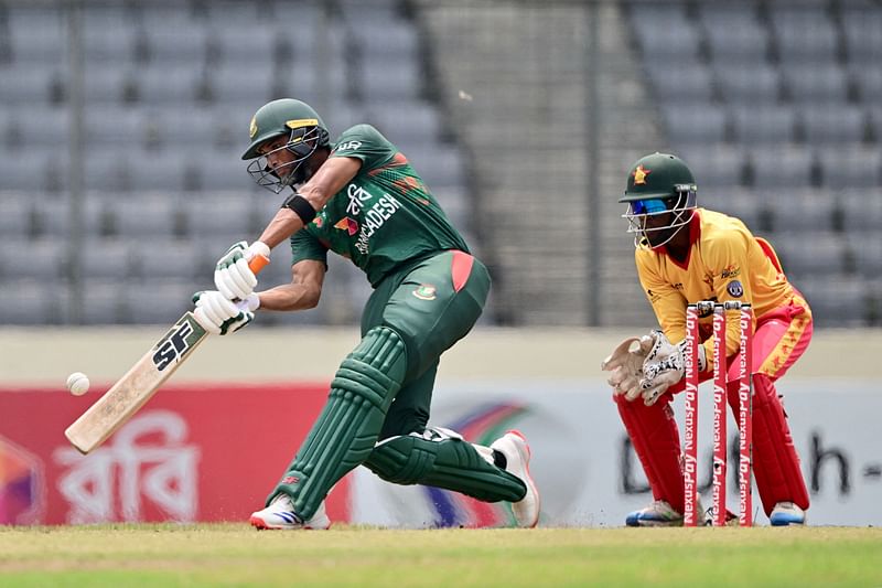 Bangladesh's Mahmudullah Riyad (L) plays a shot as Zimbabwe’s wicket keeper Clive Madande (R) looks on during the fifth Twenty20 international cricket match between Bangladesh and Zimbabwe at the Sher-E-Bangla National Cricket Stadium in Dhaka on May 12, 2024