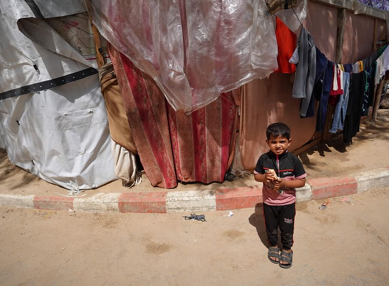 A Palestinian boy stands in front of tents set up inside the European hospital compound in Khan Yunis in the southern Gaza Strip on 17 May 2024, amid the ongoing conflict in the Palestinian territory between Israel and the militant group Hamas.