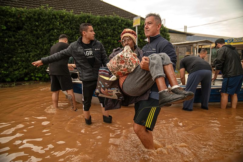 A woman is evacuated from a flooded area in Porto Alegre, Rio Grande do Sul State, Brazil, on 4 May, 2024.