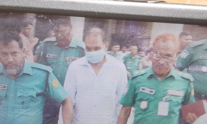 The policemen are taking Kamrul Ashraf Khan Poton from the court.