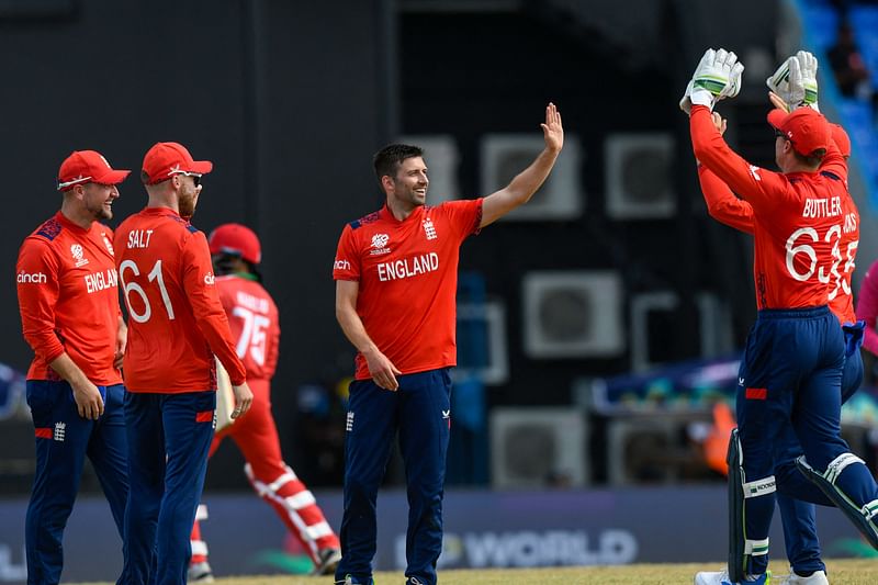 Mark Wood (C) of England celebrates the dismissal of Kashyap Prajapati of Oman during the ICC Men’s T20 CWC group B match between England and Oman at Vivian Richards Cricket Stadium in North Sound, Antigua and Barbuda, on 13 June 2024