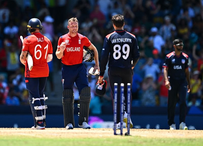 England's captain and wicketkeeper Jos Buttler (C) goes to shake hands with USA's Shadley Van Schalkwyk after England won the ICC men's Twenty20 World Cup 2024 Super Eight cricket match between USA and England at Kensington Oval in Bridgetown, Barbados on 23 June 2024.