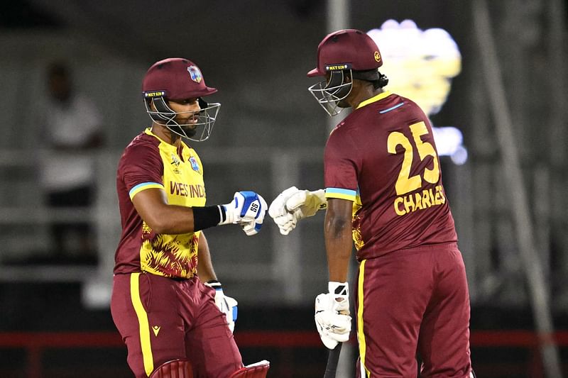 West Indies' Nicholas Pooran and West Indies' Johnson Charles bump fists during the group C cricket match between the West Indies and Afghanistan at Daren Sammy Cricket Ground in Gros Islet, St. Lucia, on 17 June, 2024.