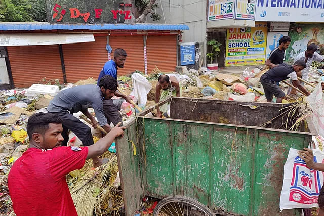 Iqbal (second from left in a black shirt) is clearing away waste