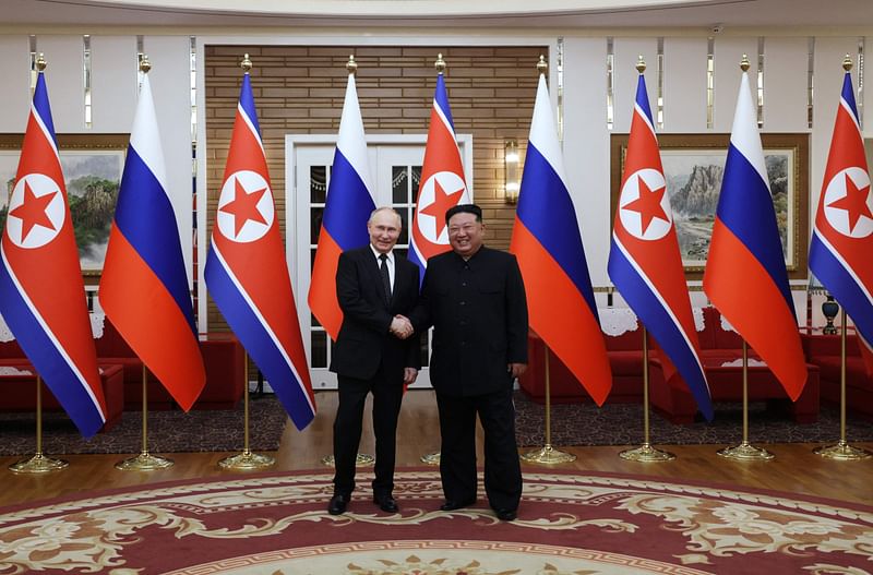 In this pool photograph distributed by the Russian state agency Sputnik, Russia's President Vladimir Putin (L) shakes hands with North Korea's leader Kim Jong Un during a meeting in Pyongyang on 19 June 2024.