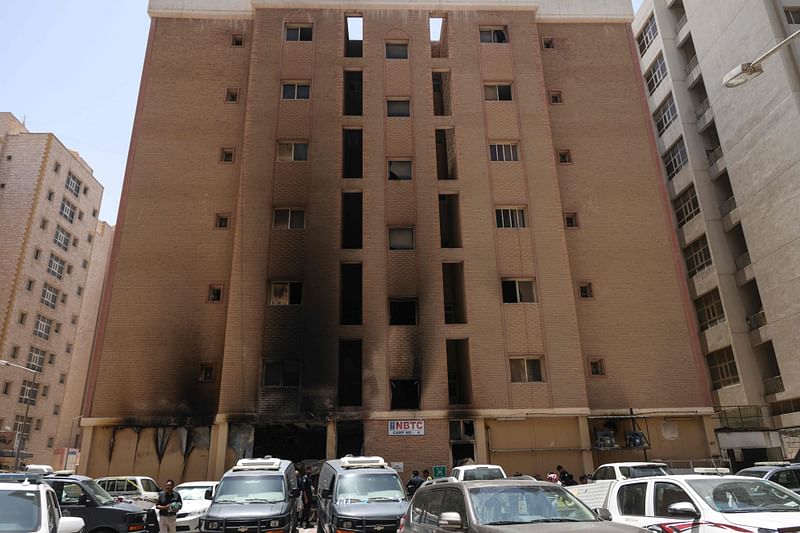 Kuwaiti security forces gather outside a building which was ingulfed by fire, in Kuwait City, on June 12, 2024.