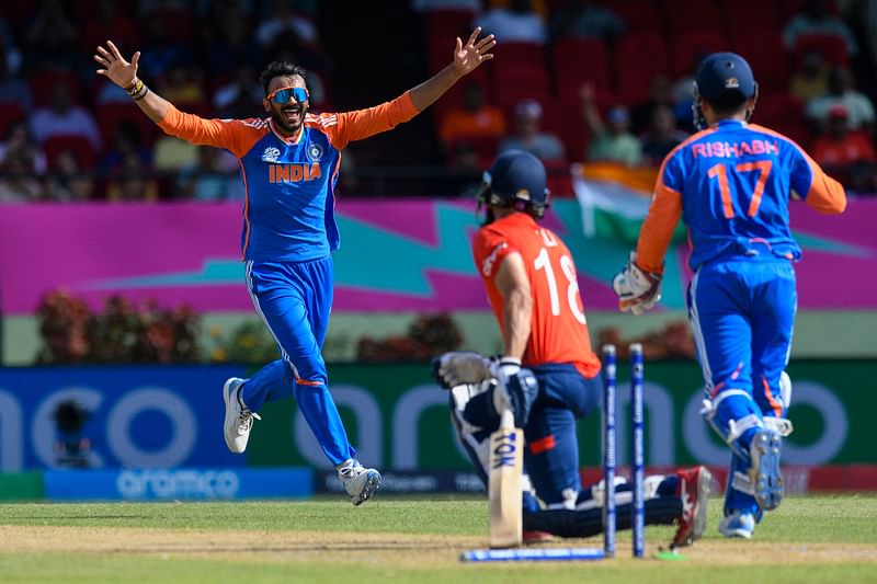 Axar Patel (L) of India celebrates the dismissal of Moeen Ali (C) of England during the ICC men's Twenty20 World Cup 2024 semi-final cricket match between India and England at Providence Stadium in Georgetown, Guyana, on 27 June, 2024.
