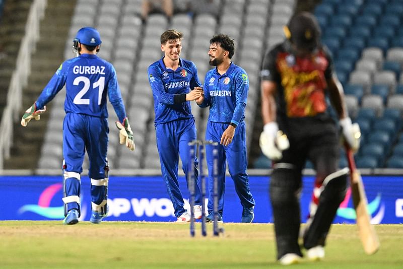 Afghanistan’s Noor Ahmad (C-R) celebrates after dismissing Papua New Guinea’s Kipling Doriga during the ICC men’s Twenty20 World Cup 2024 group C cricket match between Afghanistan and Papua New Guinea at Brian Lara Cricket Academy Stadium in Tarouba, Trinidad and Tobago, on 13 June, 2024