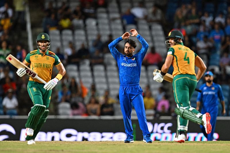 Afghanistan’s captain Rashid Khan (C) reacts as South Africa’s captain Aiden Markram (R) and South Africa’s Reeza Hendricks (L) run between wickets during the ICC men’s Twenty20 World Cup 2024 semi-final cricket match between South Africa and Afghanistan at Brian Lara Cricket Academy in Tarouba, Trinidad and Tobago, on 26 June, 2024