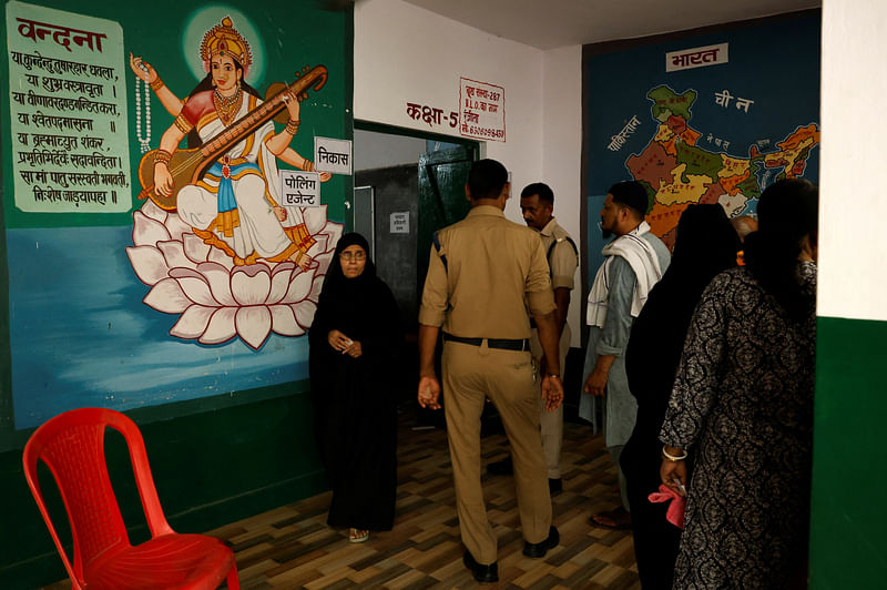 A Muslim woman leaves a polling station as others wait to vote during the seventh and last phase of India's general election in Varanasi, India, 1 June 2024.