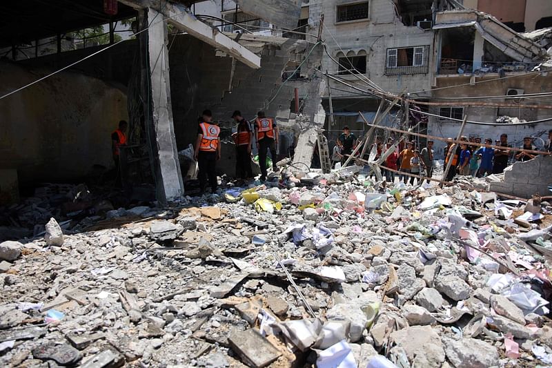 Gaza municipality employees and some civil defence workers inspect the site following the Israeli military bombardment of the Gaza Municipality garage on al-Wahda Street, in the al-Daraj neighborhood in Gaza City on 21 June 2024