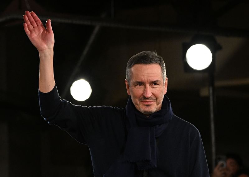 Belgium fashion designer Dries Van Noten gestures to the public during the Menswear Ready-to-wear Fall-Winter 2023-2024 collection show for Dries Van Noten at Paris fashion week on 19 January, 2023. The name will live on, but with a different designer at the helm: Belgian designer Dries Van Noten bows out on 22 June evening at a final show near Paris, after a forty-year career in which he has imposed his style, a blend of audacity, sophistication and poetry.