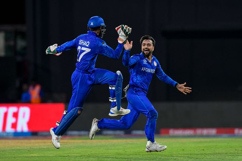 Afghanistan's captain Rashid Khan (R) and Afghanistan's Mohammad Ishaq celebrate the dismissal of Bangladesh's Rishad Hossain during the ICC men's Twenty20 World Cup 2024 Super Eight cricket match between Afghanistan and Bangladesh at Arnos Vale Stadium in Arnos Vale, Saint Vincent and the Grenadines on 24 June 2024.