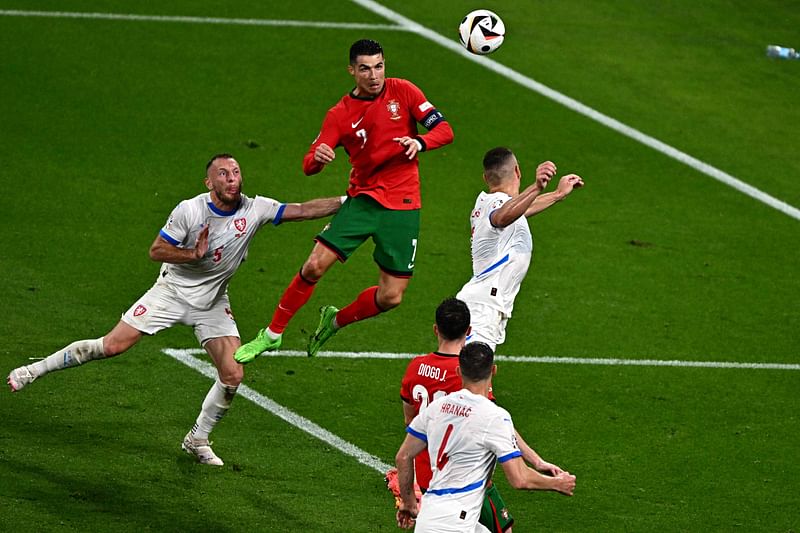 Portugal's forward #07 Cristiano Ronaldo (C) heads the ball during the UEFA Euro 2024 Group F football match between Portugal and the Czech Republic at the Leipzig Stadium in Leipzig on 18 June 2024.