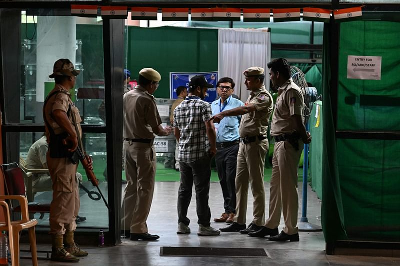 Security personnel inspect a man entering an election vote counting station in New Delhi on June 4, 2024.