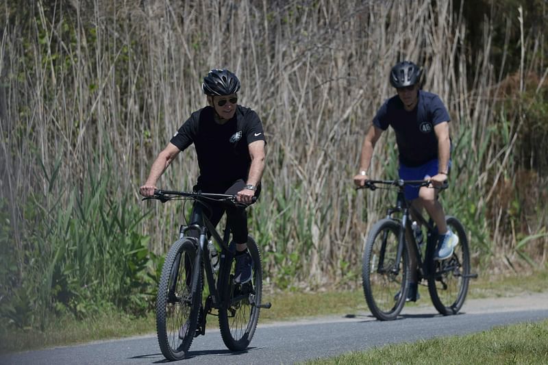 US President Joe Biden (L) with his son Hunter Biden, rides his bike at Gordons Pond in Rehoboth Beach, Delaware, on 1 June, 2024.