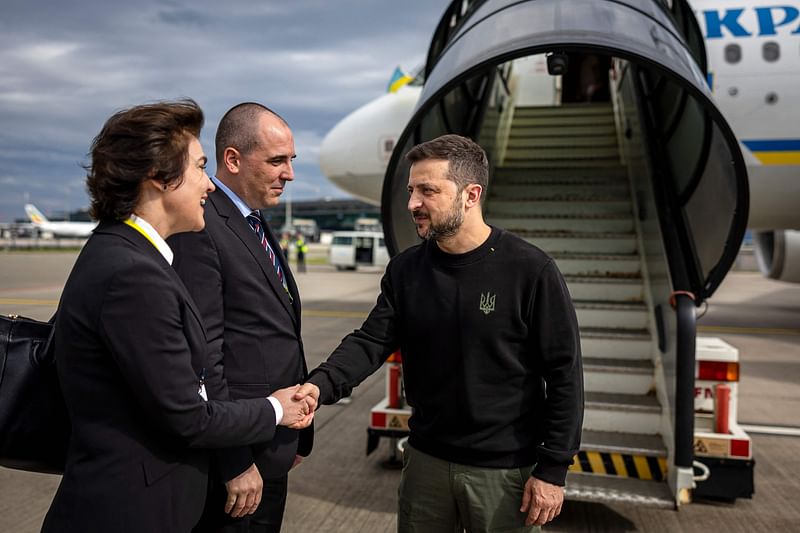 Ukraine's President Volodymyr Zelensky (C) is welcomed by Ukraine's Ambassador to Switzerland Iryna Wenediktowa (L) upon his arrival at the Zurich airport on 14 June 2024, ahead of the Ukraine Peace Summit in Switzerland.