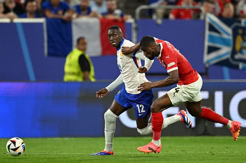 France's forward #12 Randal Kolo Muani is marked by Austria's defender #04 Kevin Danso during the UEFA Euro 2024 Group D football match between Austria and France at the Duesseldorf Arena in Duesseldorf on 17 June, 2024