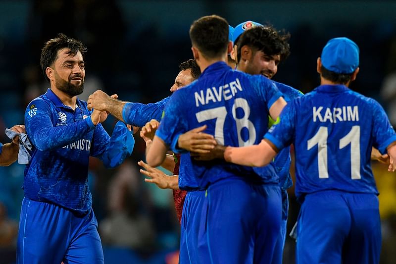 Afghanistan's captain Rashid Khan (L) celebrates his team's win of the ICC men's Twenty20 World Cup 2024 Super Eight cricket match between Afghanistan and Australia at Arnos Vale Stadium in Arnos Vale, Saint Vincent and the Grenadines on 22 June 2024