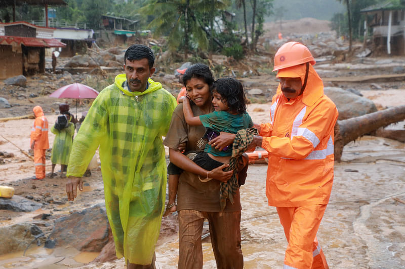 Rescuers help residents to move to a safer place, at a landslide site after multiple landslides in the hills, in Wayanad, in the southern state of Kerala, India, 30 July 2024.