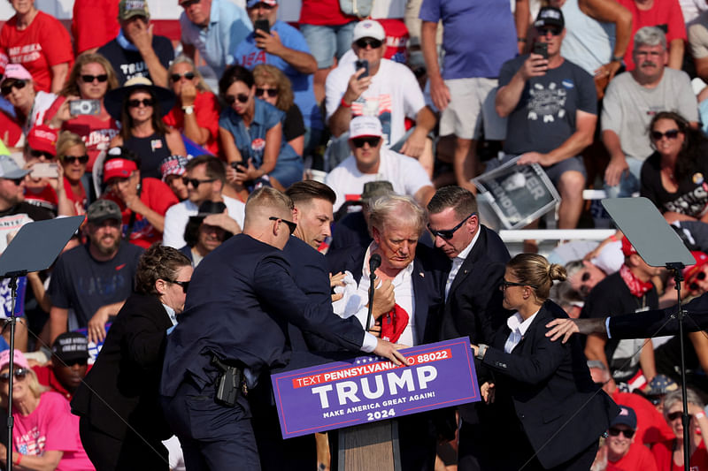 Republican presidential candidate and former US President Donald Trump he is assisted by the Secret Service after gunfire rang out during a campaign rally at the Butler Farm Show in Butler, Pennsylvania, US, 13 July 2024.