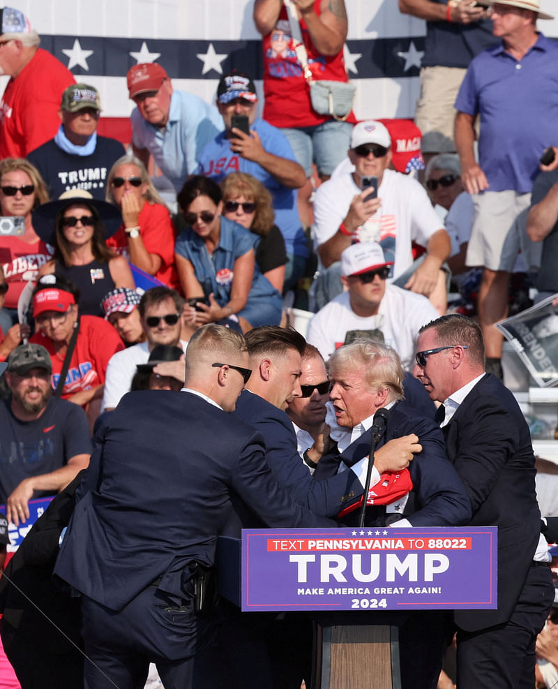 Republican presidential candidate and former US President Donald Trump he is assisted by the Secret Service after gunfire rang out during a campaign rally at the Butler Farm Show in Butler, Pennsylvania, US, 13 July 2024.