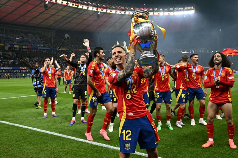 Spain's defender #12 Alejandro Grimaldo rises the trophy during a lap of honor after winning the UEFA Euro 2024 final football match between Spain and England at the Olympiastadion in Berlin on July 14, 2024