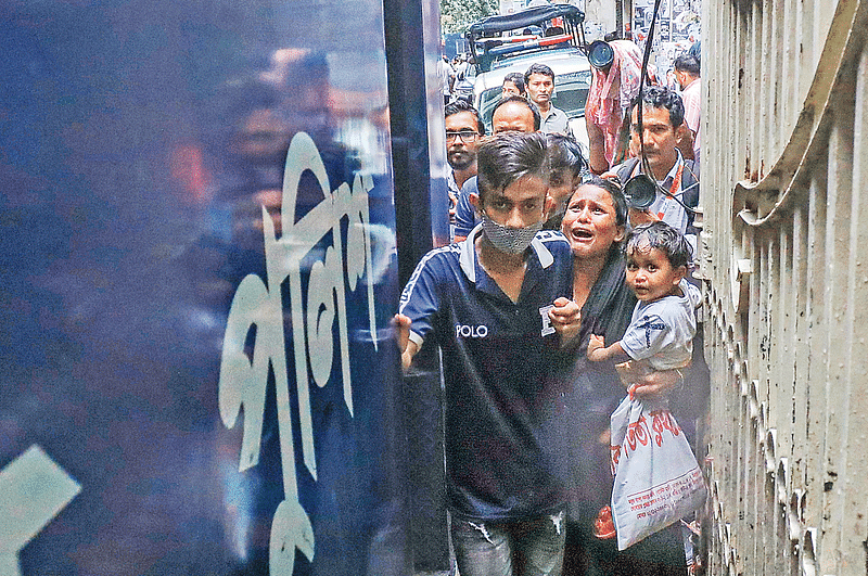 Rahima Begum, carrying her daughter, bursts into tears after seeing her husband Tuhin in a prison van. Forces from the capital’s Kalabagan police station arrested driver Tuhin when he was on returning home after work. The picture was taken from the CMM court premises on 26 July 2024.