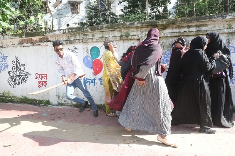 A BCL man beating up students involved with the movement indiscriminately on the road in front of the residence of Dhaka University vice chancellor