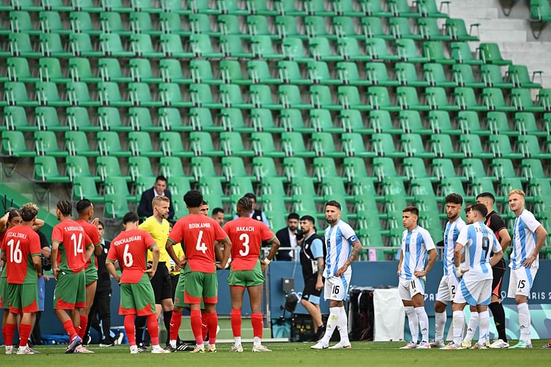 Swedish referee Glenn Nyberg (6thL) looks on as Argentina’s (R) and Morocco’s players prepare to start playing again in an emptied stadium following incidents, a two-hour interruption and the cancellation of Argentina’s equalising goal, in the men’s group B football match between Argentina and Morocco during the Paris 2024 Olympic Games at the Geoffroy-Guichard Stadium in Saint-Etienne on 24 July, 2024