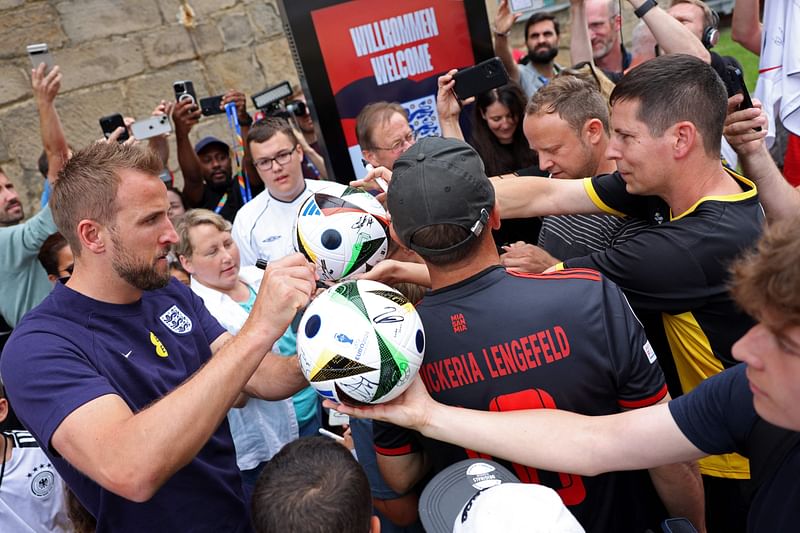 England's forward #09 Harry Kane signs autographs as he leaves the media centre at the team's base camp, the Weimarer Land golf resort, near Blankenhain, on 12 July 2024, ahead of the UEFA Euro 2024 final football match between Spain and England.