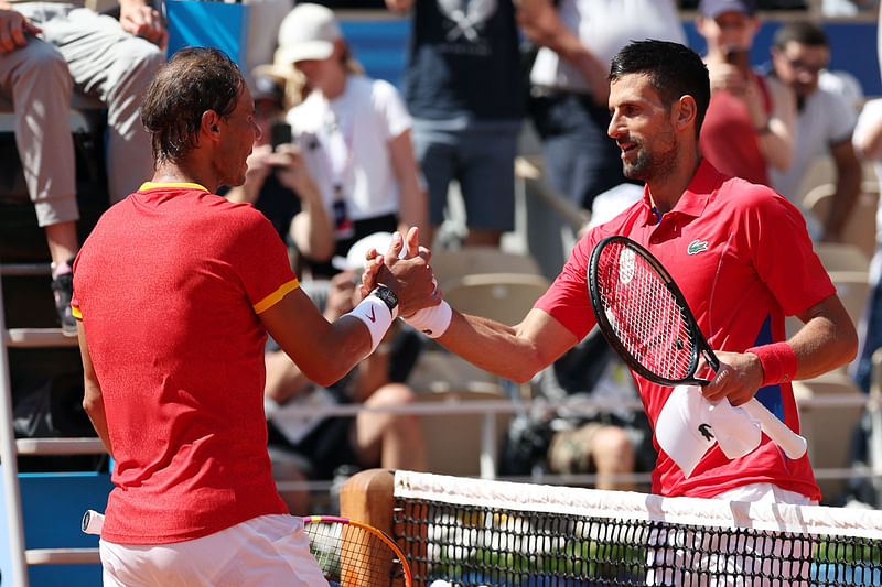 Paris 2024 Olympics - Tennis - Men's Singles Second Round - Roland-Garros Stadium, Paris, France - 29 July, 2024. Novak Djokovic of Serbia and Rafael Nadal of Spain shake hands after their match.