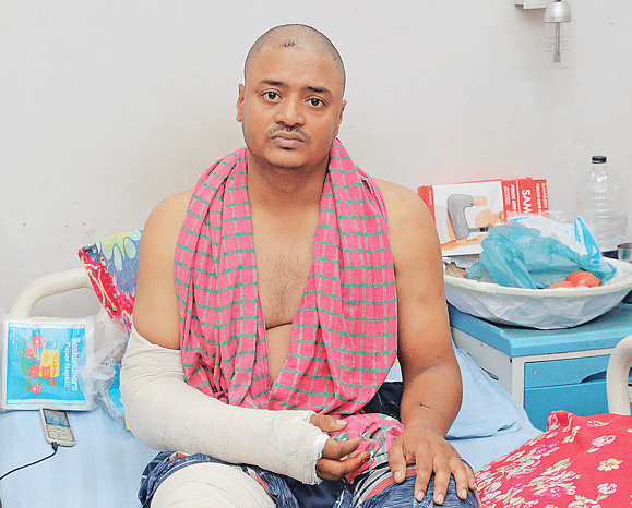 Traffic Sergeant Syed Masudur Rahman, who was injured in the protesters’ attack, sits on a bed at the Central Police Hospital in Dhaka.